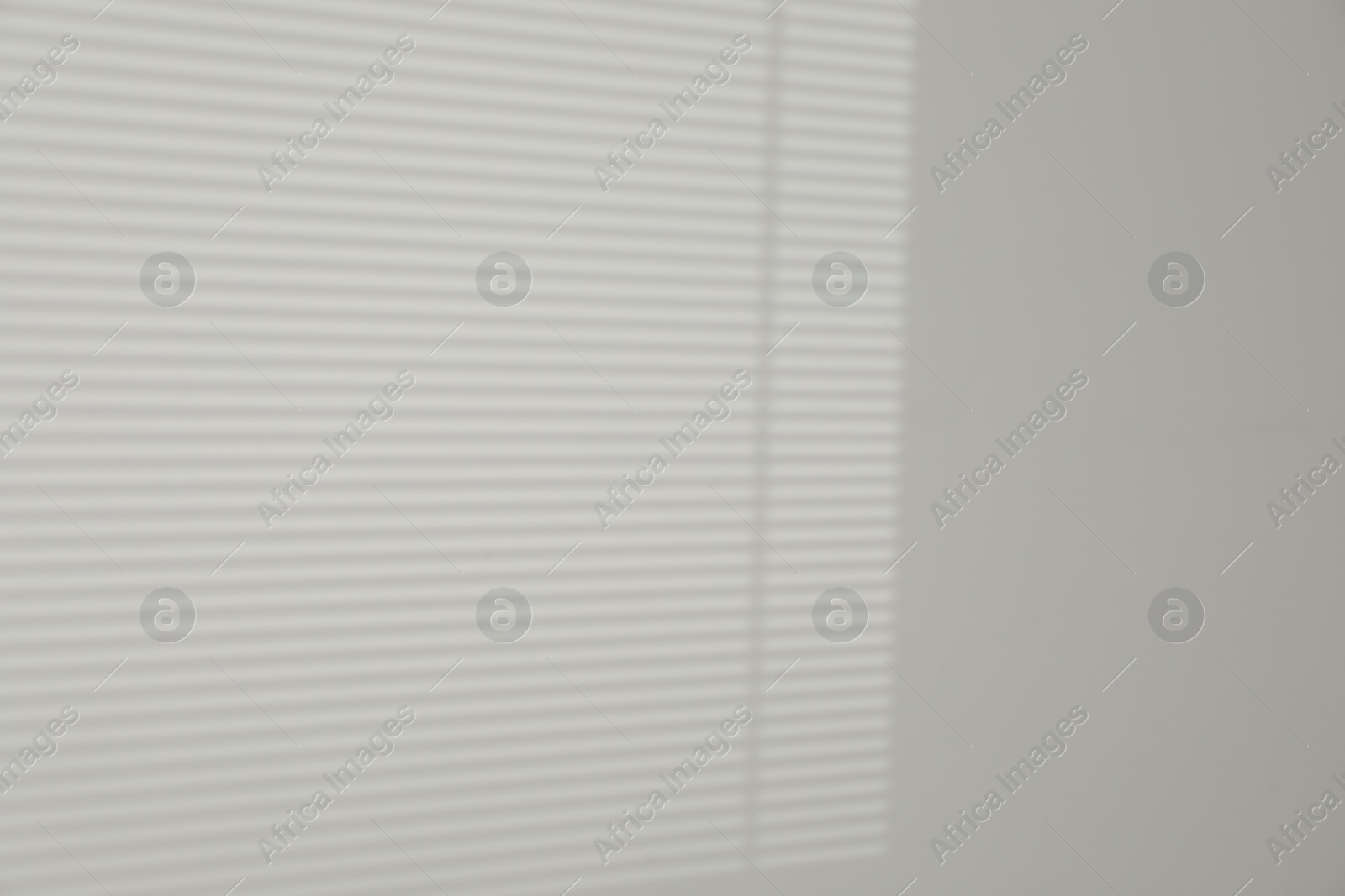 Photo of Light and shadow from window shutters on white wall, space for text