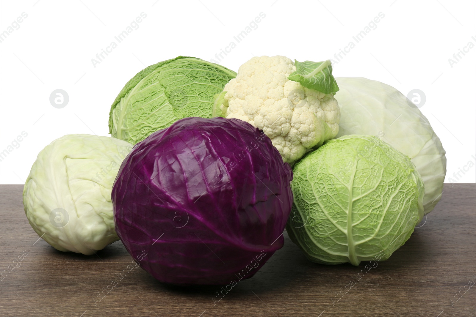 Photo of Many different fresh ripe cabbages on wooden table
