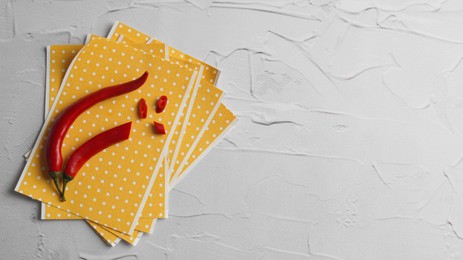 Pepper plasters and chili on white textured table, flat lay. Space for text