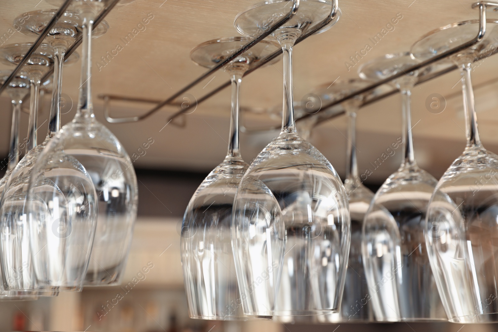 Photo of Set of empty clean glasses on bar racks