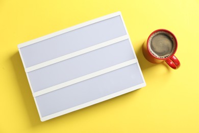 Photo of Blank letter board and coffee on yellow background, flat lay