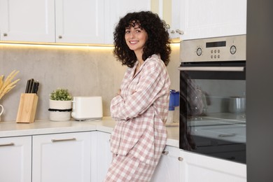 Beautiful young woman in stylish pyjama in kitchen