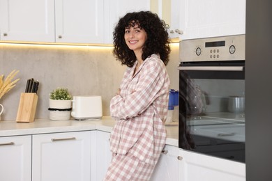 Photo of Beautiful young woman in stylish pyjama in kitchen