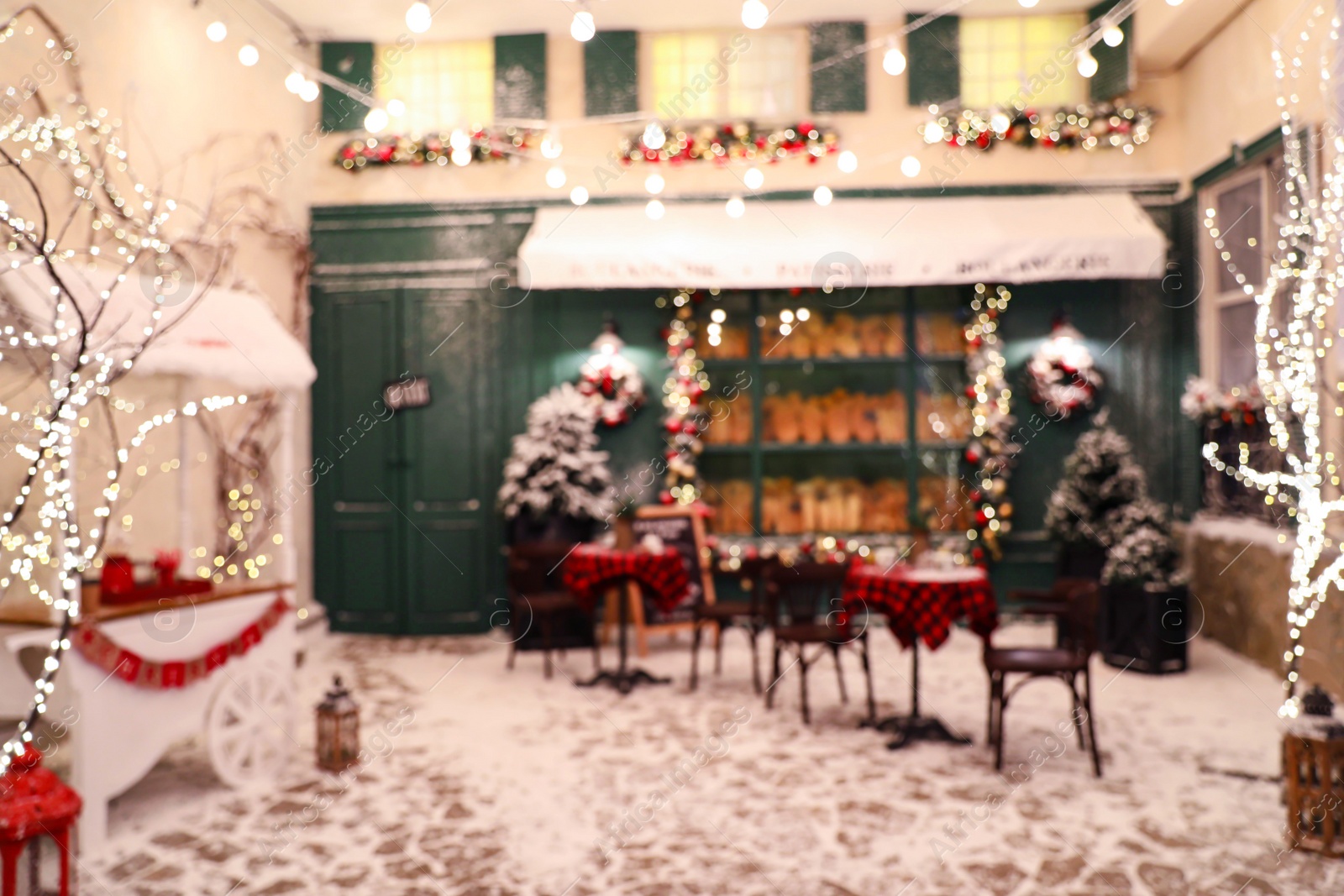 Photo of Blurred view of modern outdoor cafe in winter. Christmas holiday
