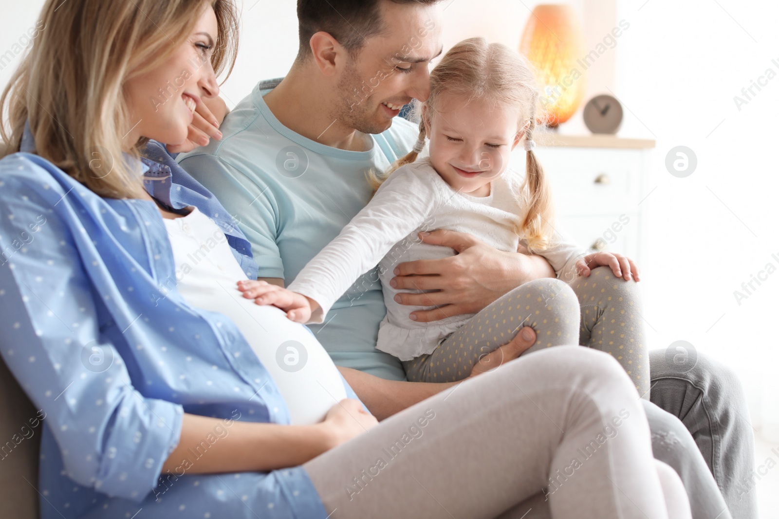 Photo of Young pregnant woman with her family at home