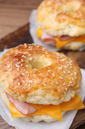 Photo of Delicious bagels with ham and cheese on table, closeup