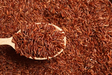 Photo of Brown rice in wooden spoon, closeup view