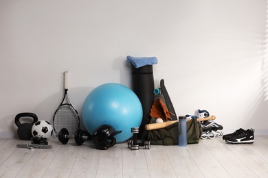 Photo of Many different sports equipment near wall indoors