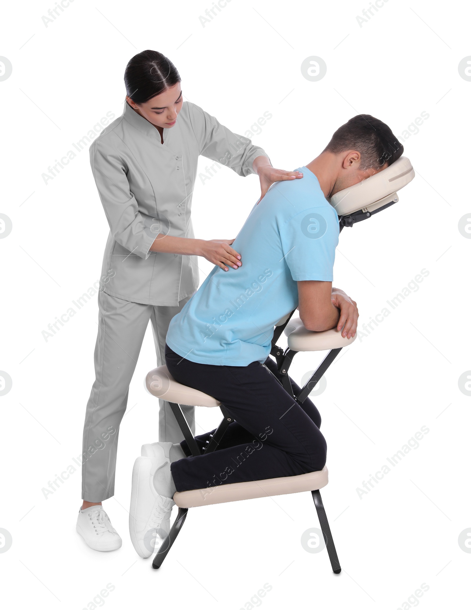 Photo of Man receiving massage in modern chair on white background