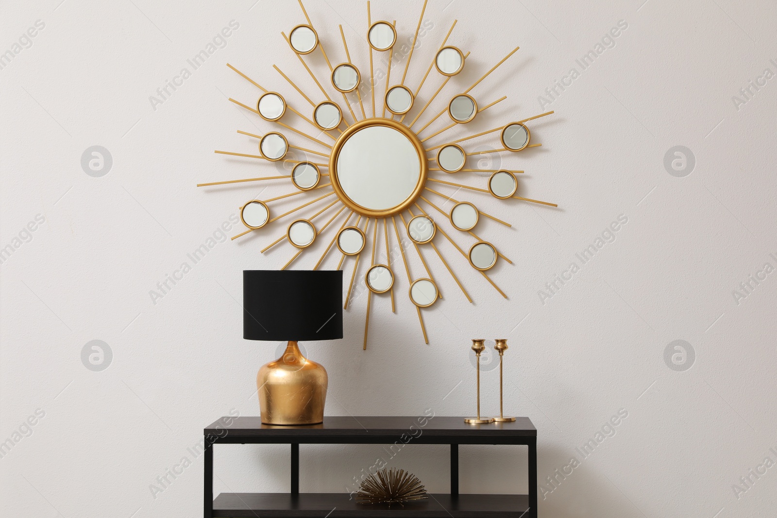 Photo of Console table near white wall with mirror in hallway. Interior design