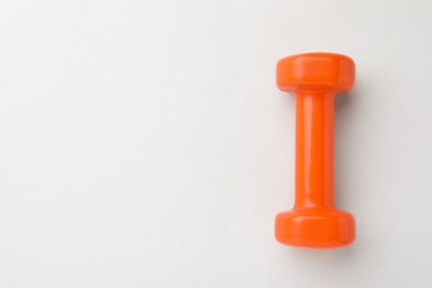 Photo of Orange vinyl dumbbell on light background, top view. Space for text