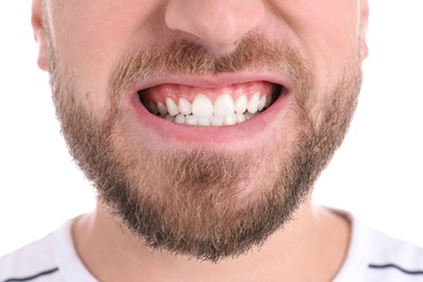 Young man with healthy teeth smiling on white background, closeup