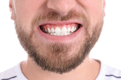 Photo of Young man with healthy teeth smiling on white background, closeup