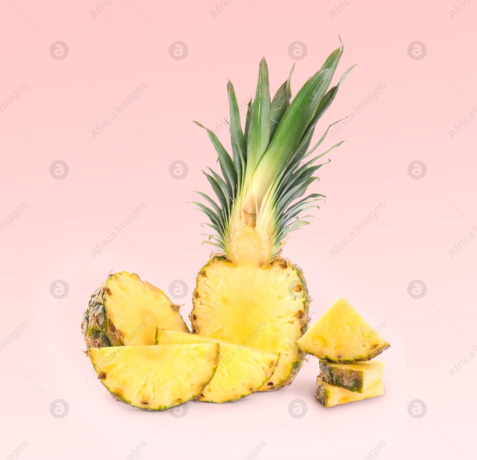 Image of Cut fresh juicy pineapples on light red background