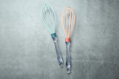 Photo of Two whisks on gray table, top view