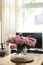 Beautiful pink peonies in vase on table at home, space for text. Interior design