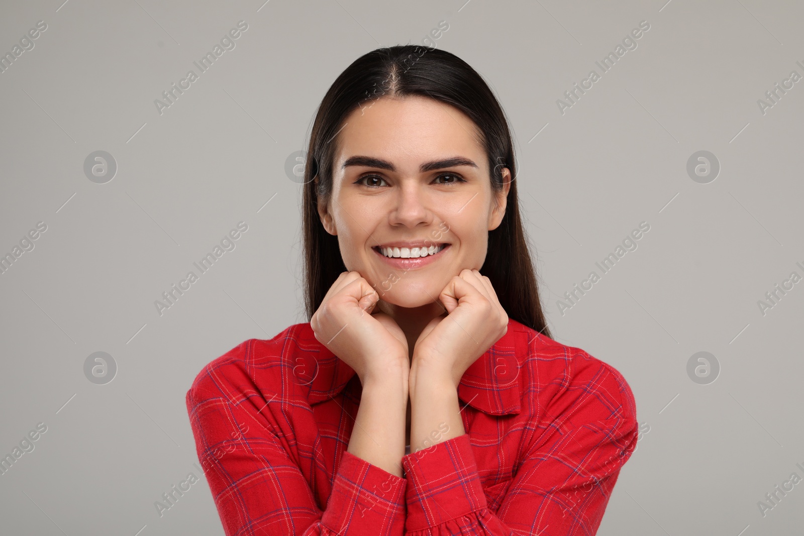 Photo of Young woman with clean teeth smiling on light grey background