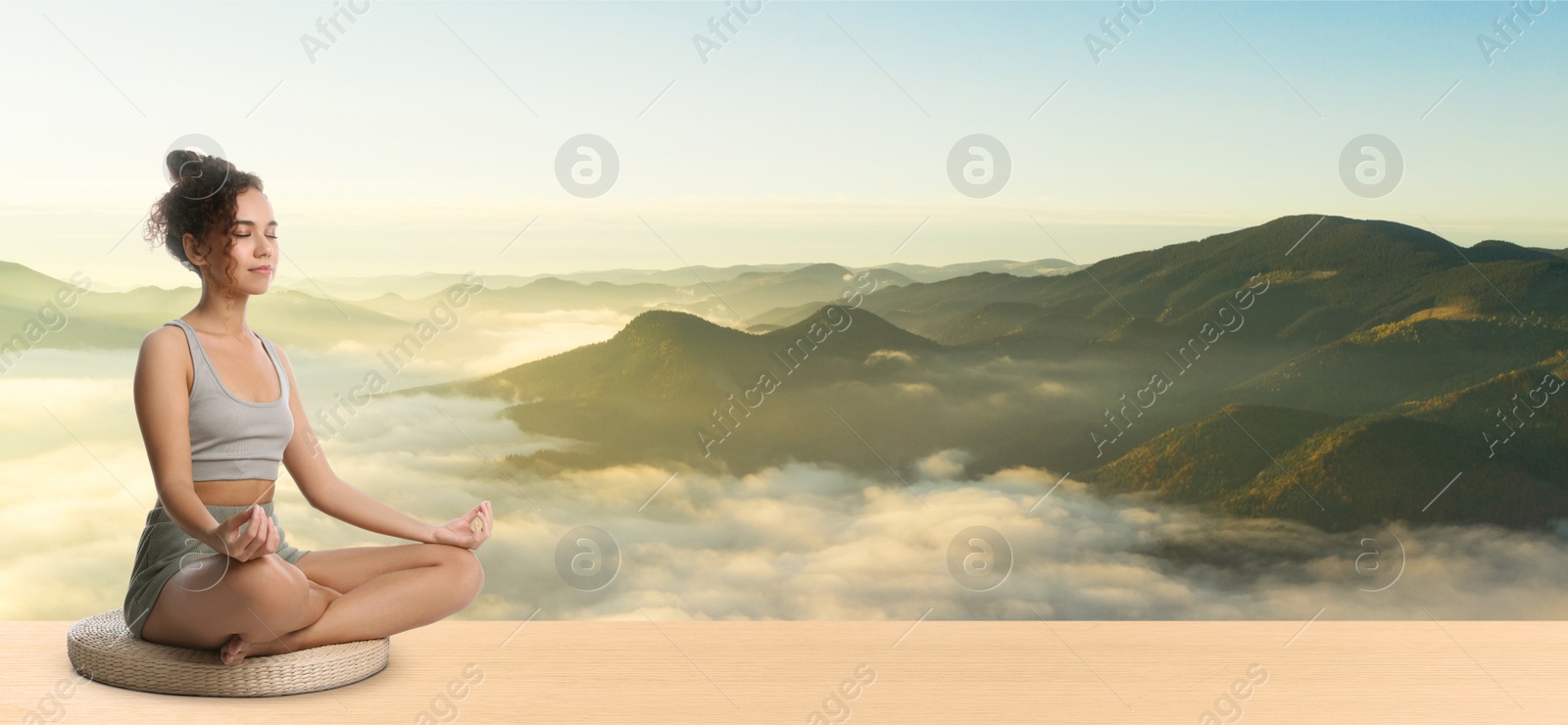 Image of Young African American woman practicing yoga on wooden surface against beautiful mountain landscape, space for text. Banner design