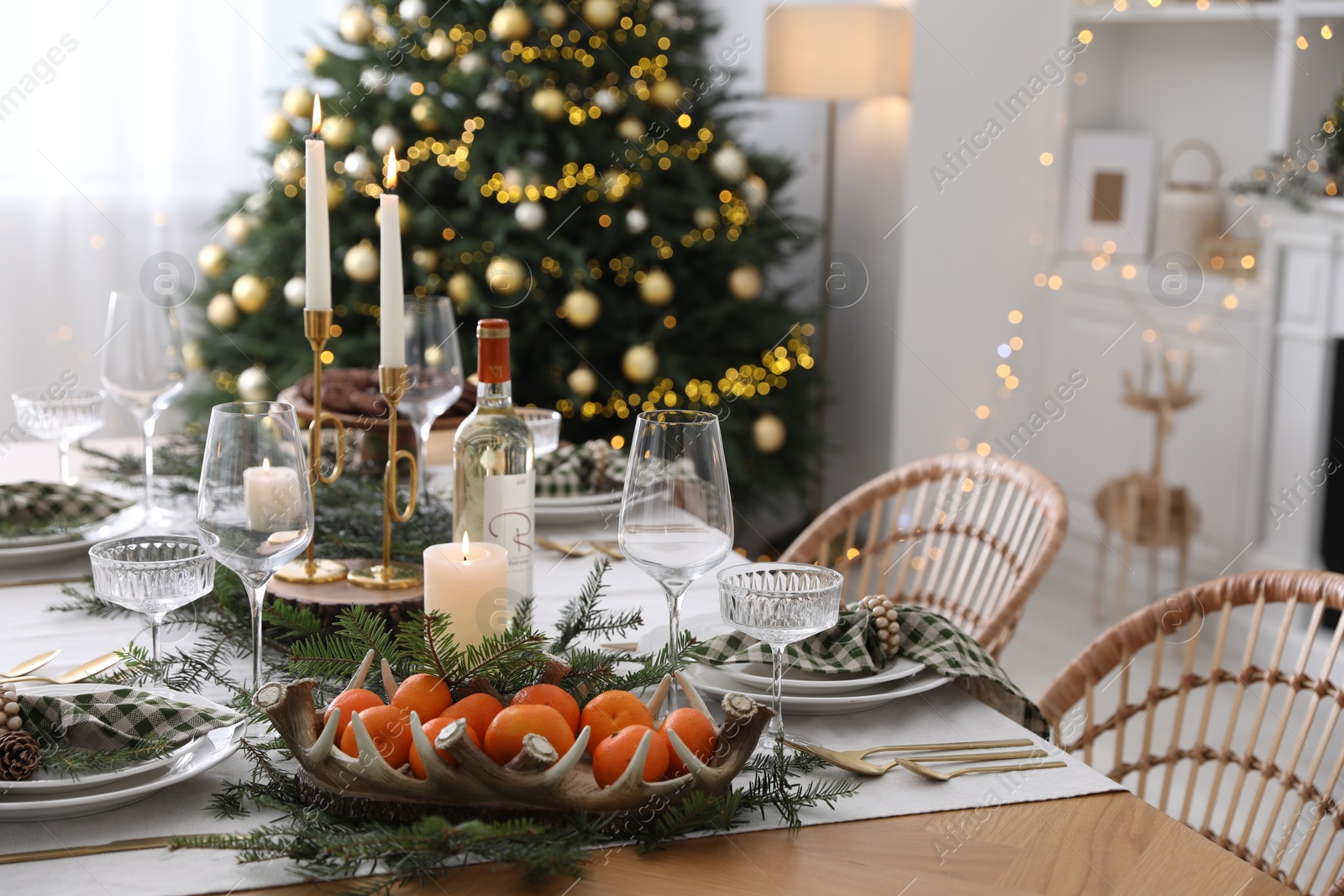 Photo of Christmas table setting with festive decor and dishware in room