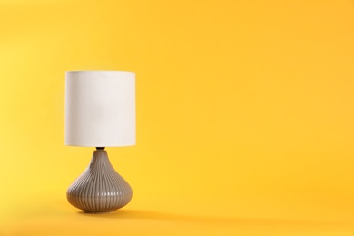 Photo of Stylish new night lamp on yellow background. Space for text