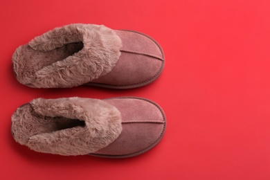 Pair of stylish soft slippers on red background, flat lay. Space for text