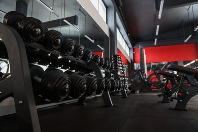 Photo of Many different dumbbells on stand in gym