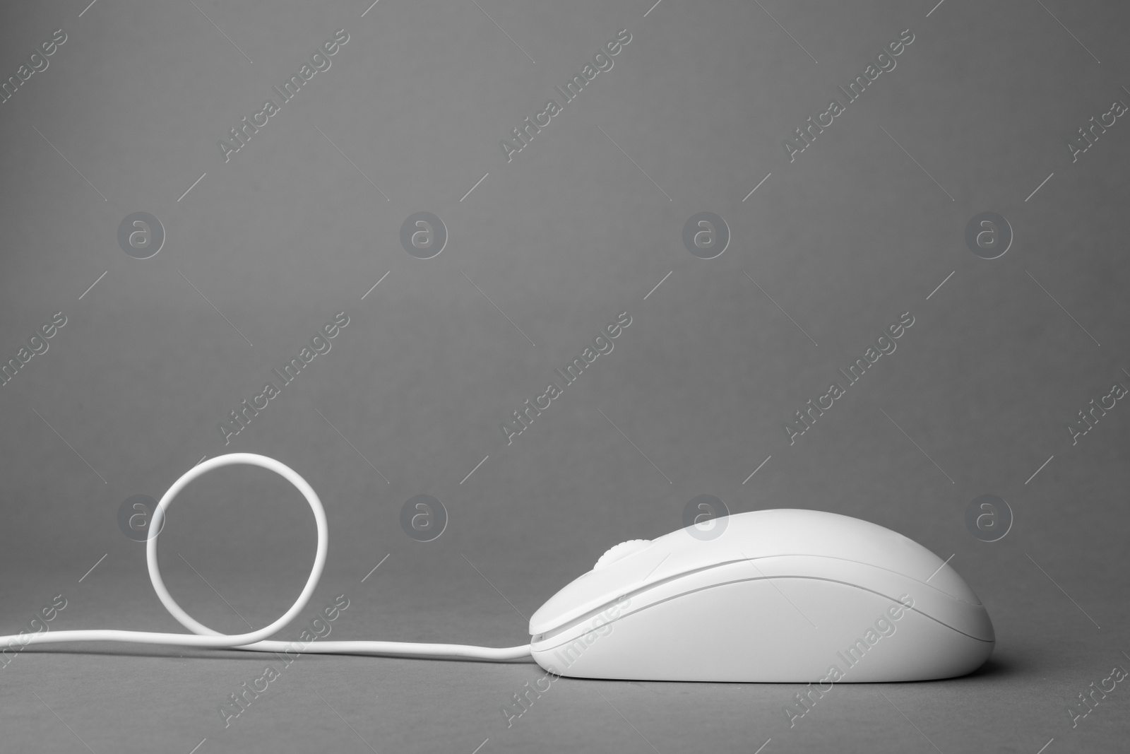 Photo of Modern wired computer mouse on grey background. Space for text