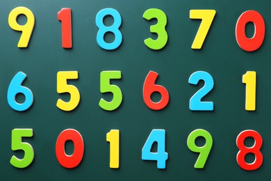 Photo of Colorful numbers on green background, flat lay