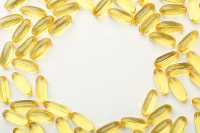 Photo of Frame made of yellow vitamin capsules on white background, top view. Space for text