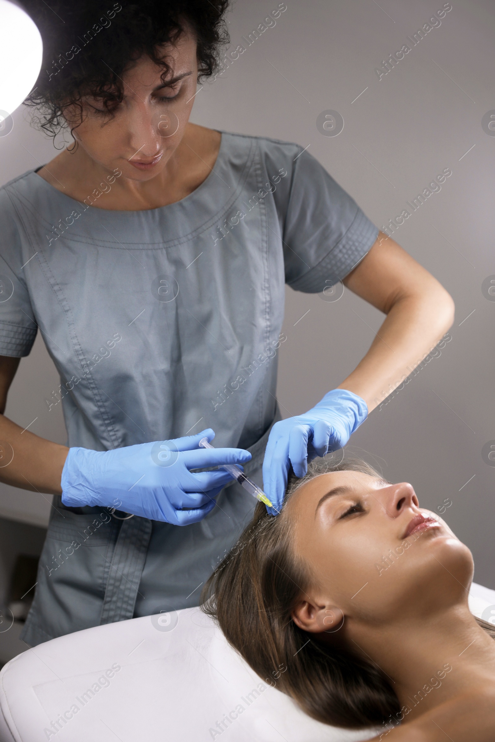 Photo of Beautiful woman getting facial injection in salon