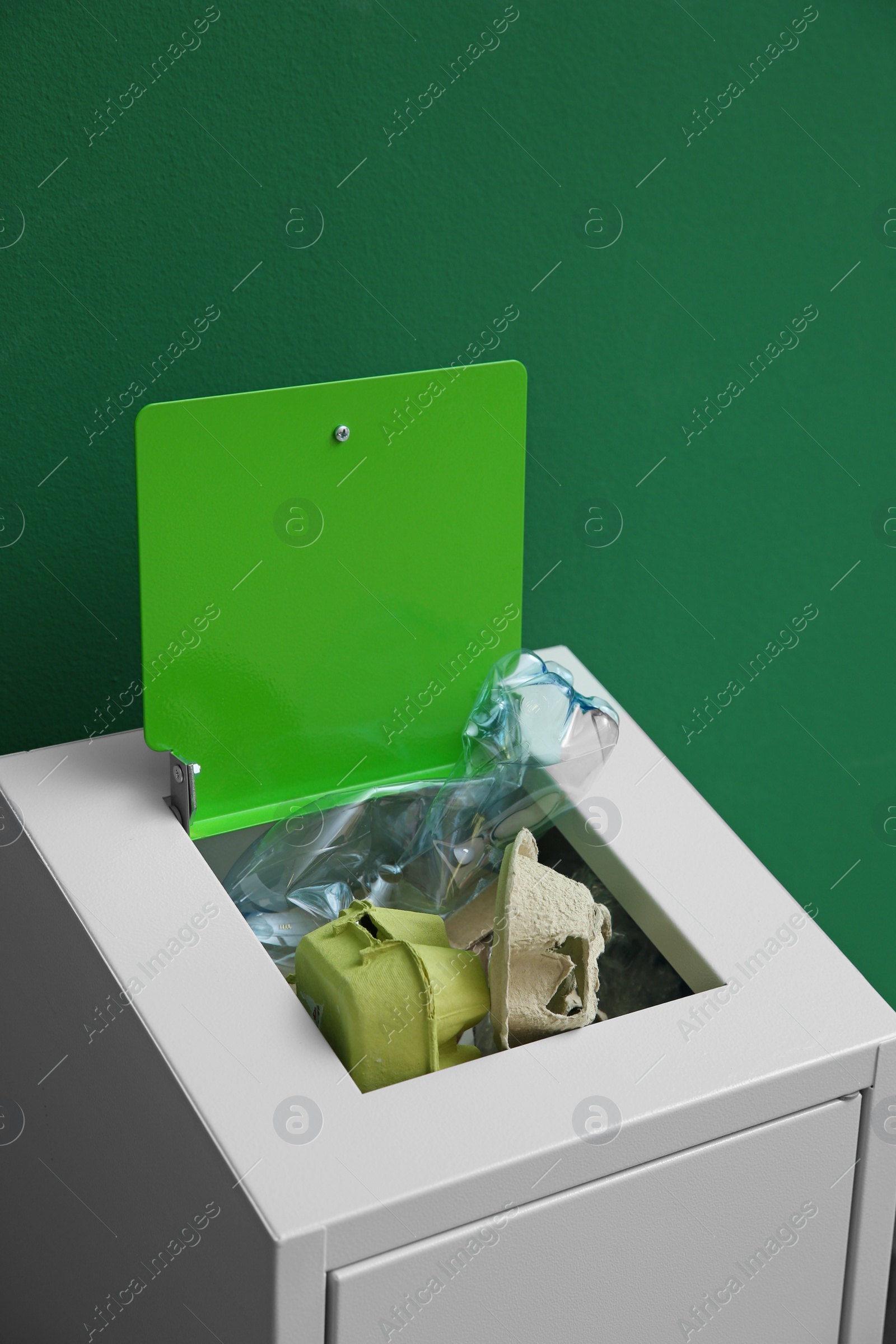 Photo of Overfilled trash bin on color background. Recycling concept