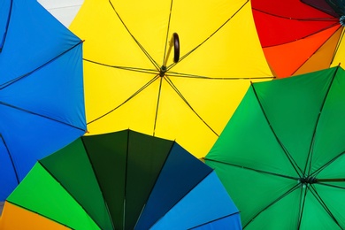 Photo of Many stylish colorful umbrellas as background, closeup