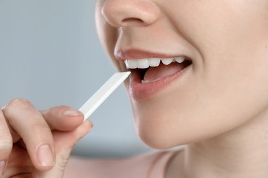 Photo of Woman with chewing gum on blurred background, closeup