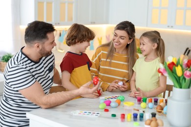 Photo of Happy Easter. Cute family with painted eggs at white marble table in kitchen