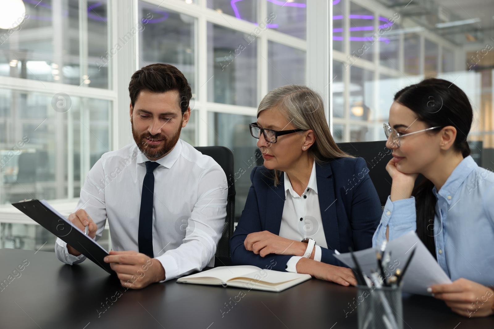 Photo of Lawyers working together at table in office