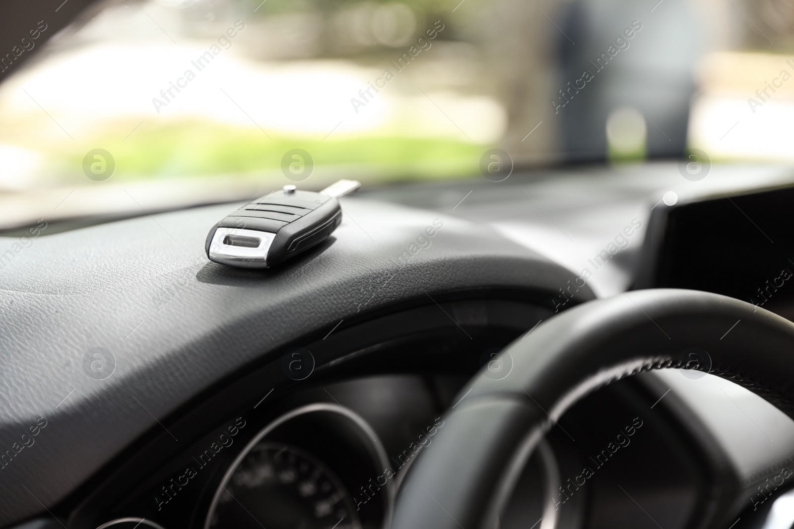 Photo of Car key on dashboard in auto against blurred background