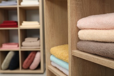 Photo of Different colorful bed linens and towels on display in home textiles store, closeup