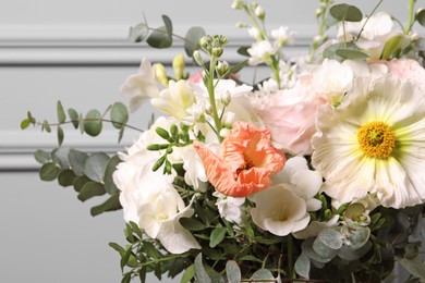 Bouquet of beautiful flowers near light wall, closeup