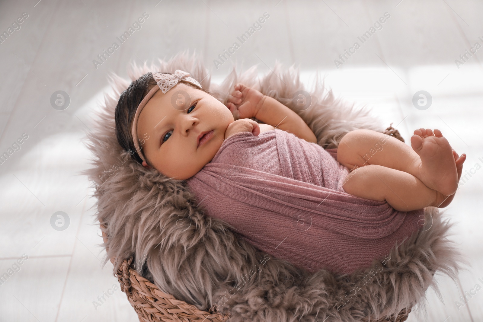 Photo of Cute newborn baby lying in wicker basket