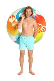 Photo of Attractive young man in swimwear with colorful inflatable ring on white background