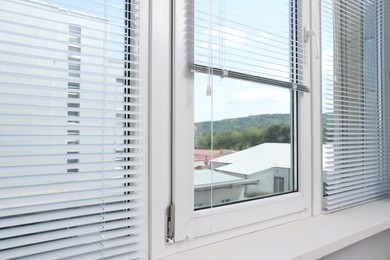 Photo of Window with horizontal blinds and white frame indoors