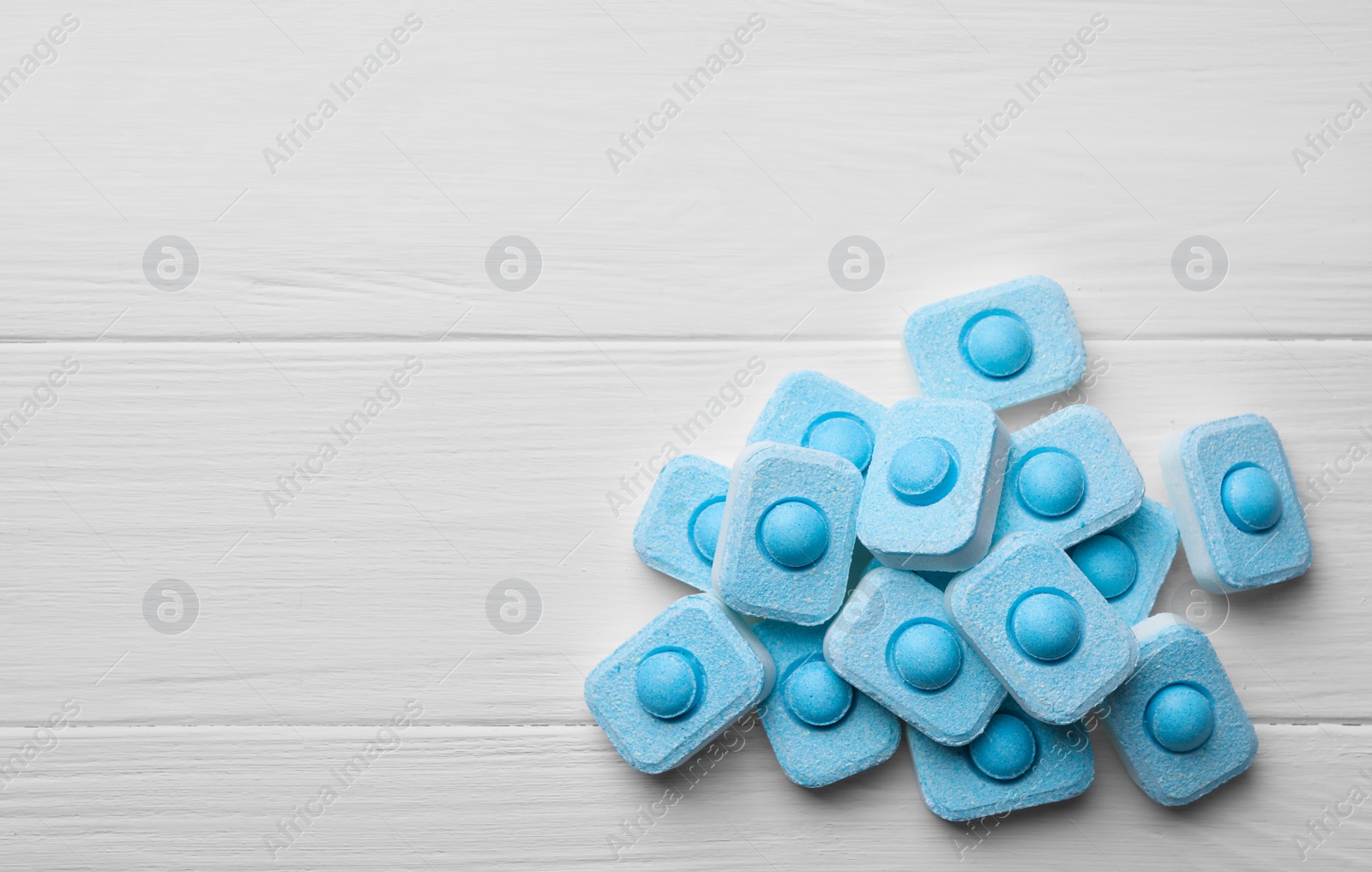 Photo of Water softener tablets on white wooden table, flat lay. Space for text