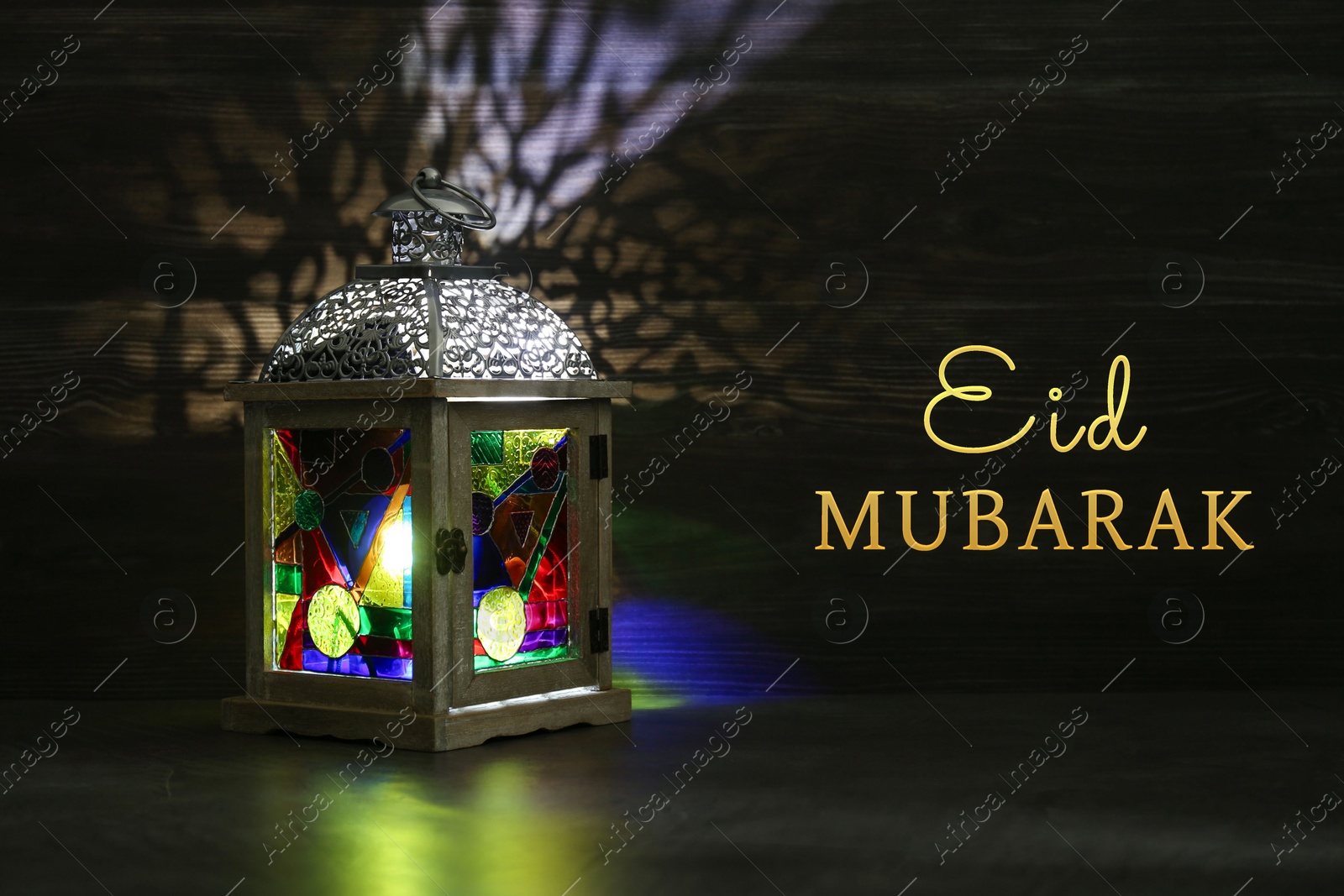 Image of Eid Mubarak greeting card. Arabic lantern indoors at night