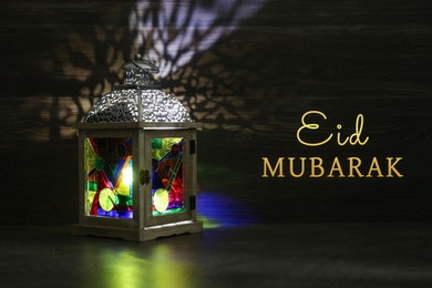 Image of Eid Mubarak greeting card. Arabic lantern indoors at night