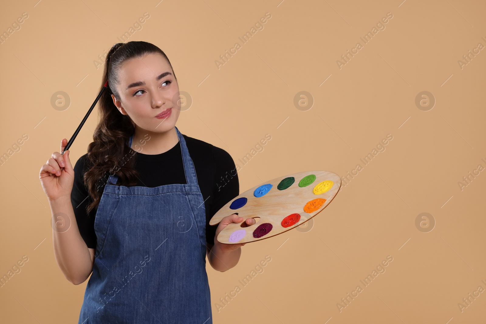 Photo of Woman with painting tools on beige background, space for text. Young artist