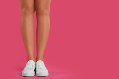 Photo of Woman wearing shoes on pink background, closeup. Space for text