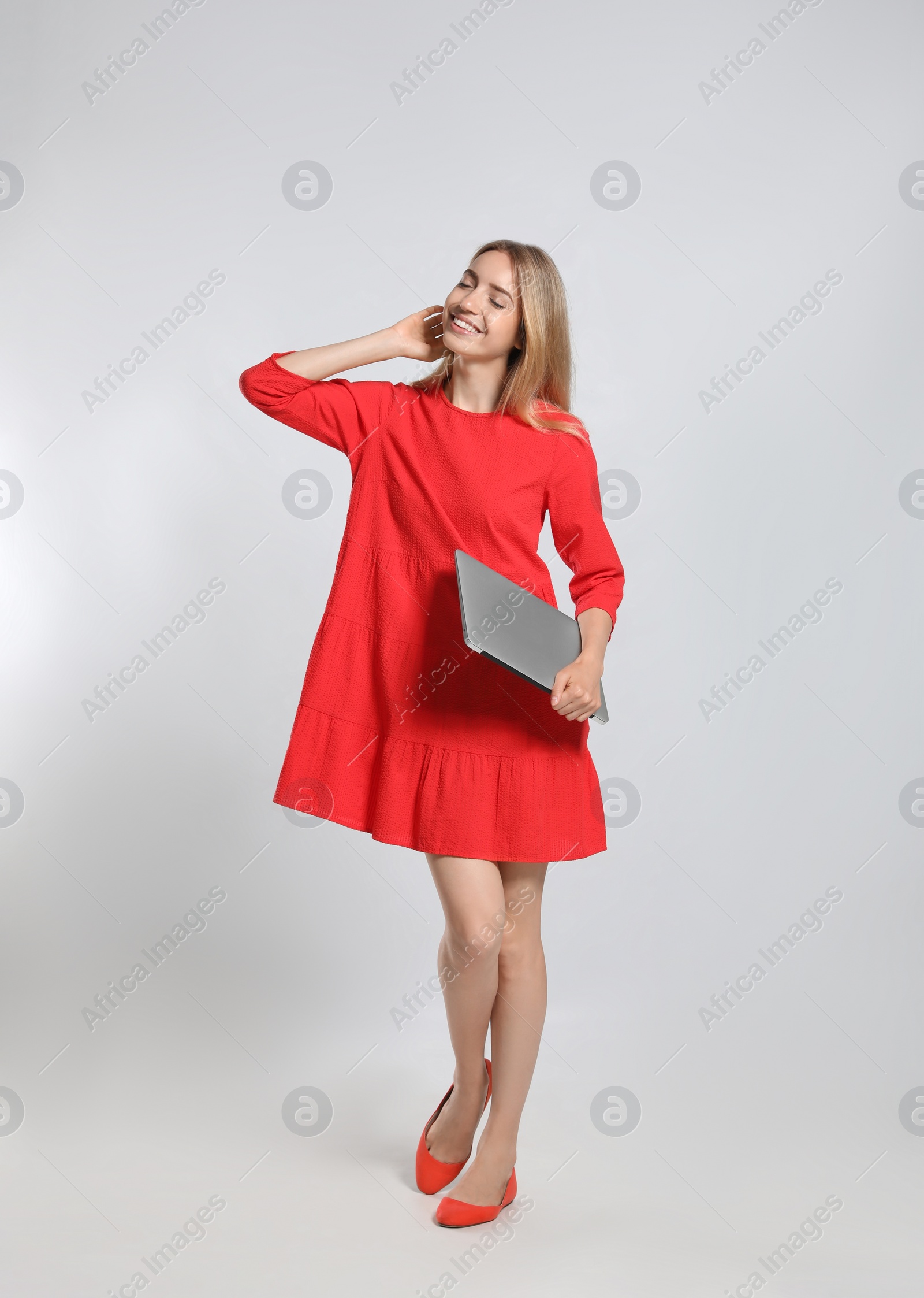 Photo of Full length portrait of young woman with modern laptop on light grey background