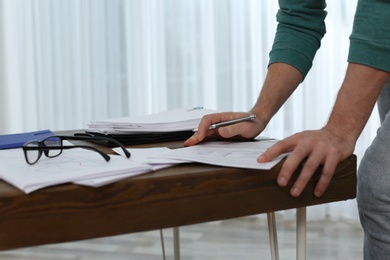 Businessman working with documents at office table, closeup