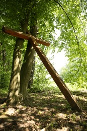 Wooden cross near trees in park outdoors