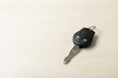 Car key on wooden background. Space for text